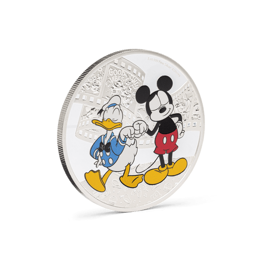 Add some bromance with this adorable 3oz pure silver coin for Disney’s Mickey Mouse and Donald Duck! Shows the two beloved best friends in colour, wearing their classic get-up and sharing a fist bump, which stands out against the mirrored background. - New Zealand Mint